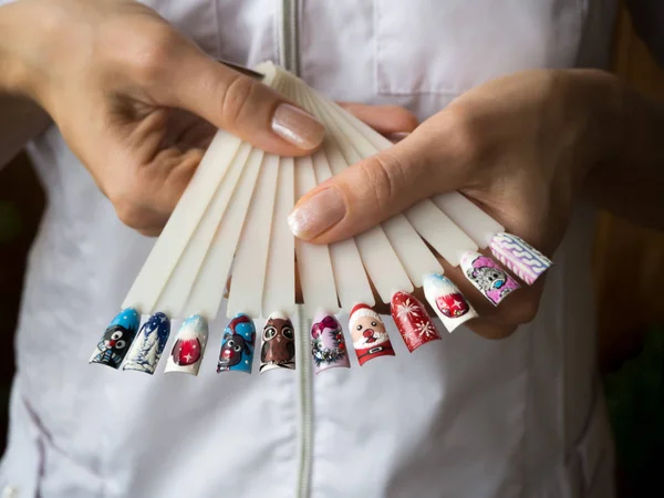 Ventilator met een verzameling van tips in de hand van de meester. Het concept van schoonheid nagels. — Stockfoto