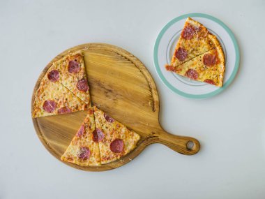 Biberli pizza beyaz masaya dilimlenmiş. Üstten görünüm.