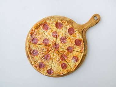 Biberli pizza beyaz masaya dilimlenmiş. Üstten görünüm.