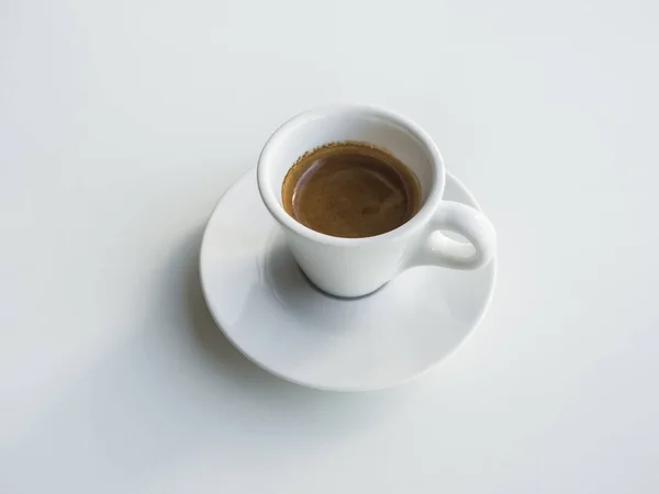 Белая чашка с черным кофе на белом столе . — стоковое фото