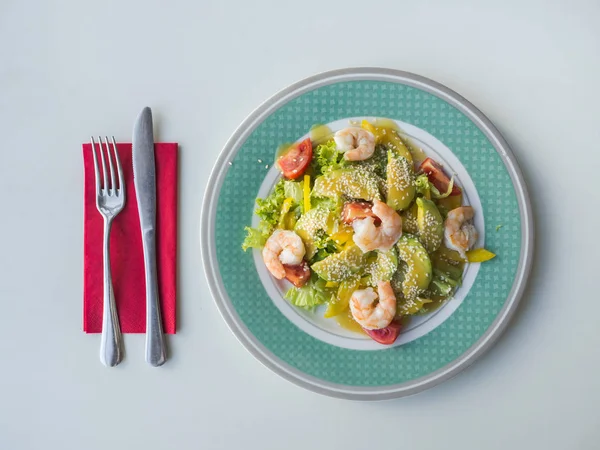 Salad with shrimp and avocado on a plate.