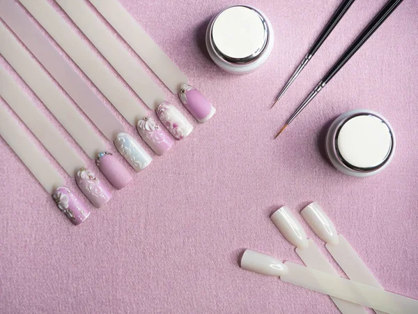 Set para dibujo de uñas sobre fondo rosa . — Foto de Stock