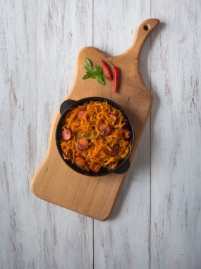 Sosis bir bölümü Pan ile haşlanmış lahana. Üstten görünüm.