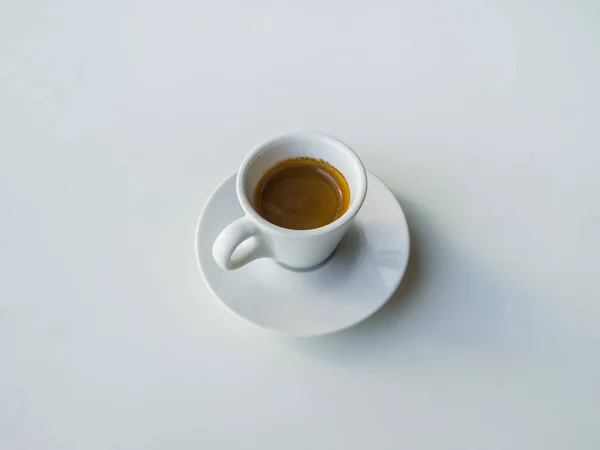 Eine Tasse starken schwarzen Kaffee auf einem weißen Tisch. — Stockfoto