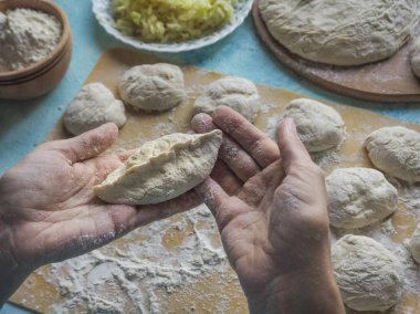 Aşçıların elinde küçük bir pasta. Turta doldurma ile hazırlanması.
