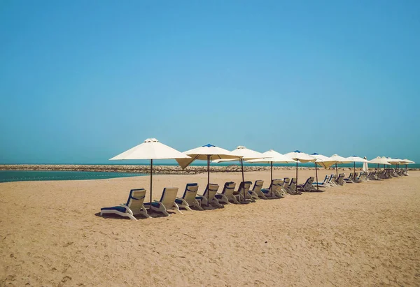 Das Ufer des arabischen Golfs. das emirat ras al khaimah. schöner Meer-Minimalismus mit Sonnenschirmen und gelbem Sand. — Stockfoto