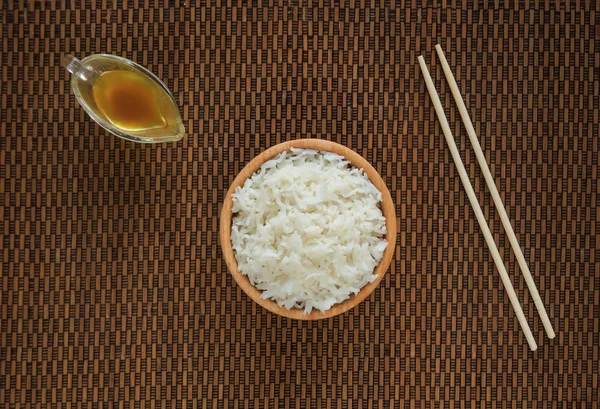 Biały ryż basmati i pałeczki na serwetki bambusowe. — Zdjęcie stockowe