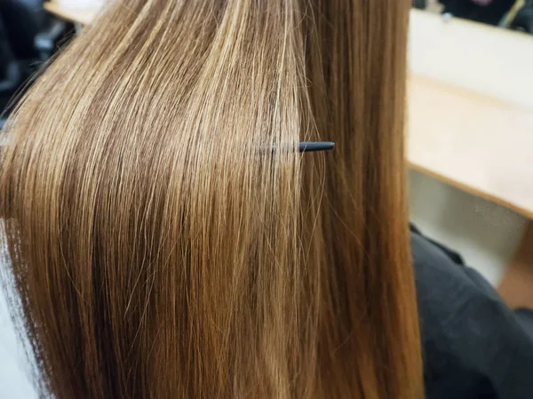 A strand of hair after the straightening procedure.