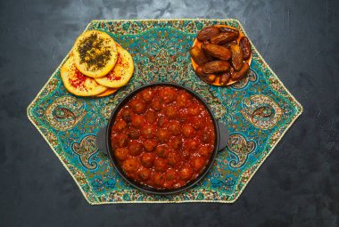 Siyah bir tabloda bir tavada ihale sırlı köfte.