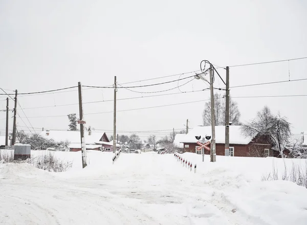 村で雪に覆われた踏切. — ストック写真