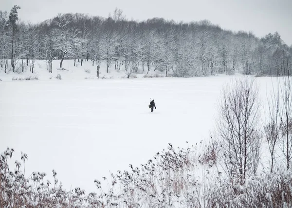 Рыбак идет по замерзшему озеру . — стоковое фото
