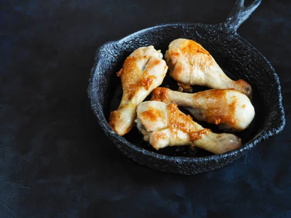 Siyah bir tablo üzerinde eski bir Pan kızarmış tavuk budu.