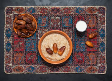 Tarihleri siyah masanın üzerine sütlü yulaf ezmesi.