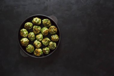 Siyah bir zemin üzerine dökme demir tavada köfte