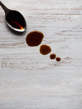 Soya sosu ahşap masa üzerinde sızıntı ile kaşık.