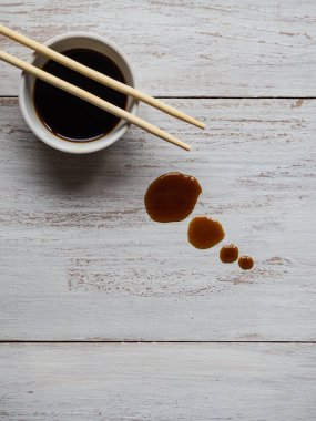 Yemek çubukları ve beyaz tahta masada soya sosu.