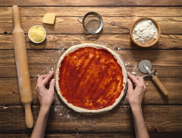 Cozinhar pizza. Molho de tomate em uma massa de farinha de pizza crua . — Fotografia de Stock