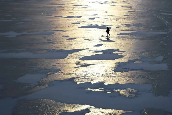 Silhueta de um homem caminhando sobre o gelo . — Fotografia de Stock