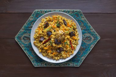 Özbek pilavı kahverengi ahşap bir masa üzerinde bir tabak içinde. 