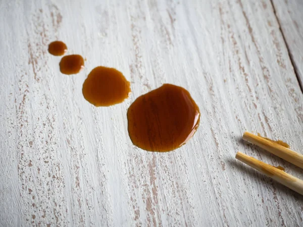 Drops of soy sauce on the table. Close up.
