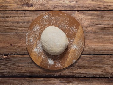 Çiğ hamur yuvarlak kesme tahtası üzerinde. Rustik mutfağı