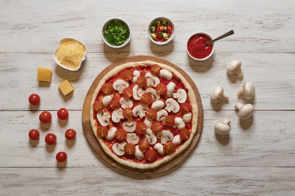 Położyć surowe pizza z pomidorami i grzybami płaskie. — Zdjęcie stockowe