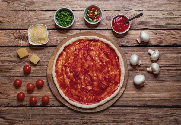 Cozinhar pizza. Rolando a massa em uma placa . — Fotografia de Stock