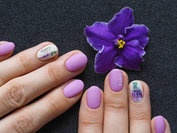 Fashionable lilac manicure design in the hand.