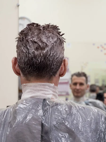 El hombre elige la pintura para teñirse el pelo. Hombre tonificando el cabello — Foto de Stock