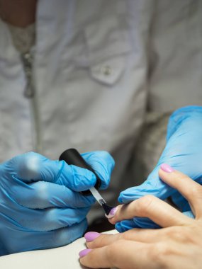 Tırnak cilası tırnak salonu içinde uygulanıyor. Yakın çekim.