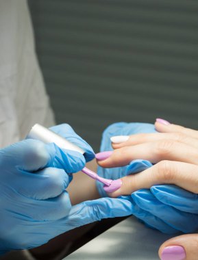 Tırnak cilası tırnak salonu içinde uygulanıyor. Yakın çekim.