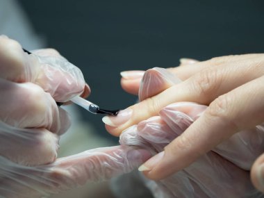 Tırnak cilası tırnak salonu içinde uygulanıyor. Yakın çekim.