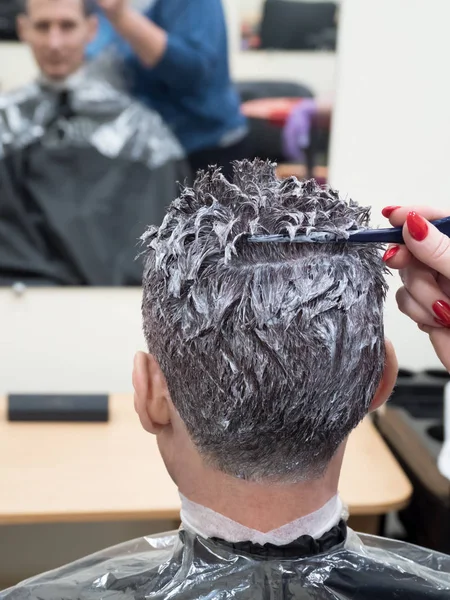 Тонирование седых волос на голове мужчины в салоне красоты — стоковое фото