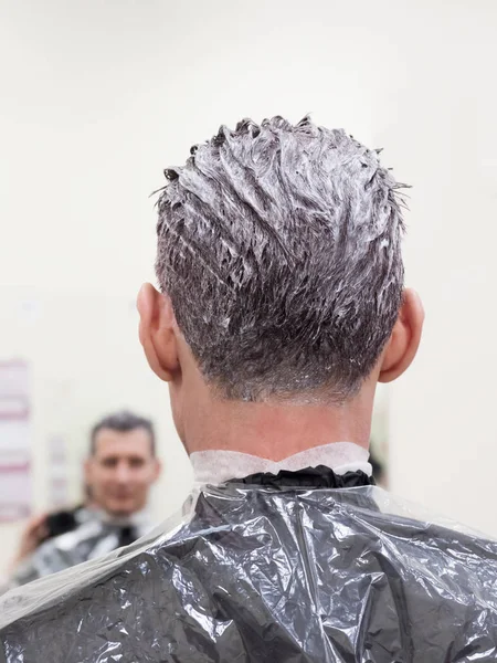 Tonificando el pelo gris en la cabeza del hombre en el salón de belleza — Foto de Stock