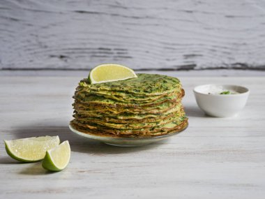 Gluten ücretsiz ıspanaklı krep beyaz bir tablo. 