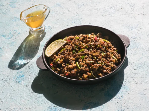 Indisches Hackfleisch qeema auf einem sonnigen blauen Tisch. — Stockfoto