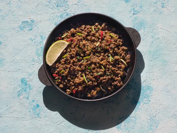 Indisches Hackfleisch qeema auf einem sonnigen blauen Tisch. — Stockfoto