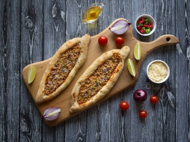 Türk pizzaları düz bir koyu ahşap masada yatıyordu. 