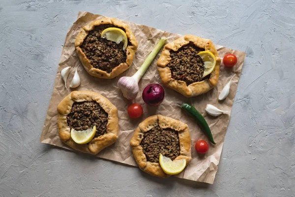 Arabian opened meat pies on gray background. — Stock Photo, Image
