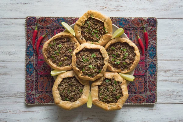 Arabian opened meat pies on white wood background. — Stock Photo, Image