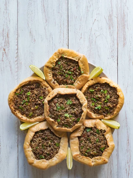 Arabic meat sfiha over a wooden table. Top view of arabic esfiha.