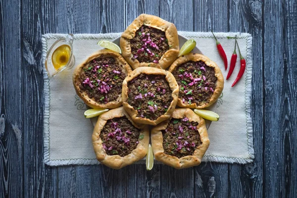 Open meat pies on dark wooden background. Top view — Stock Photo, Image