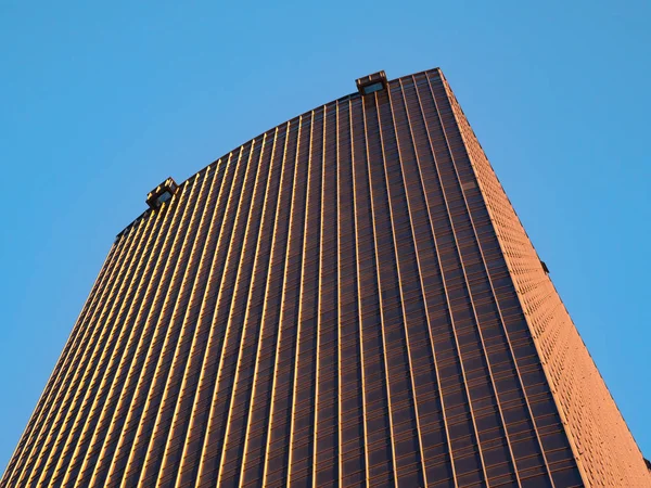 Vista inferior del rascacielos dorado contra el cielo azul . — Foto de Stock