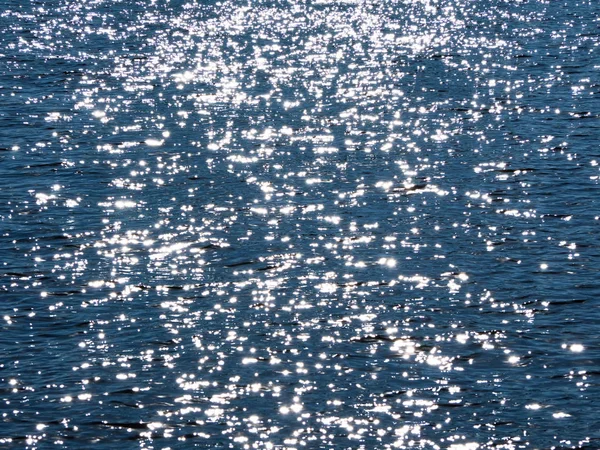 Riverbero sulla superficie dell'acqua blu . — Foto Stock