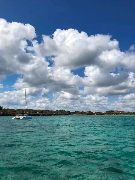 Türkisfarbener Meeresgrund mit Wolken, Himmel und mit Katamaran auf dem Wasser — Stockfoto