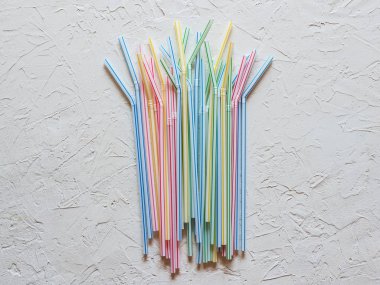 Beyaz bir masada renkli plastik içme pipetleri.