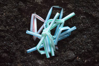 Kırık plastik kahve pipetleri toprağa gömüldü
