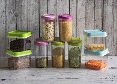 Ahşap bir masa üzerinde plastik kaplarda Tahıllar.