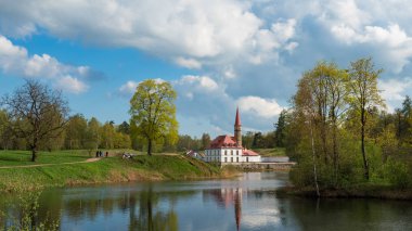 Su kenarındaki bir kale ile güneşli bahar manzarası.