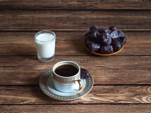 Koffie met dadels en een glas melk op een donkere houten tafel — Stockfoto